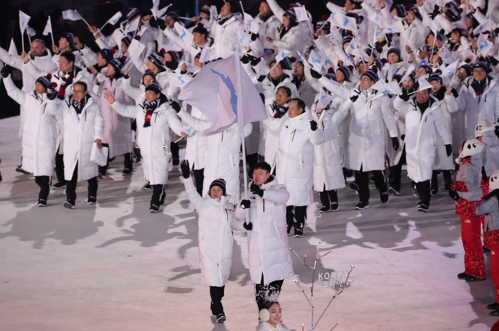 Đoàn vận động viên hai miền Triều Tiên cùng diễu hành chung dưới lá cờ mang hình một bán đảo Triều Tiên thống nhất tại lễ khai mạc Olympic PyeongChang 2018. (Nguồn: YONHAP/ TTXVN)