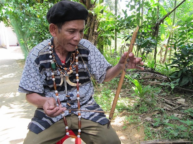 An old Cơ Tu man plays a string instrument (abel).