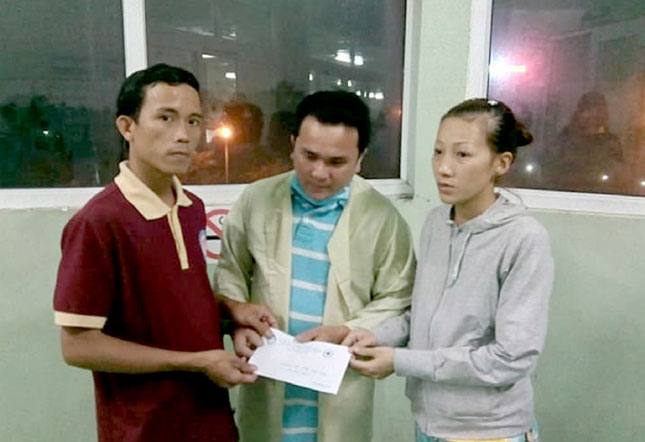Anh Nguyễn Ngọc Bình (bìa trái) trao hỗ trợ một gia đình khó khăn ở phường Hòa An, quận Cẩm Lệ.