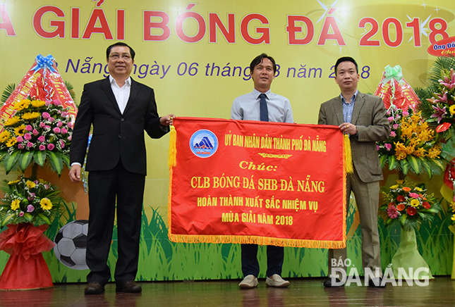Chairman Tho (left) presenting laudatory banner to head coach Phuong and a representative from the SHB DANANG SPORT JSC.