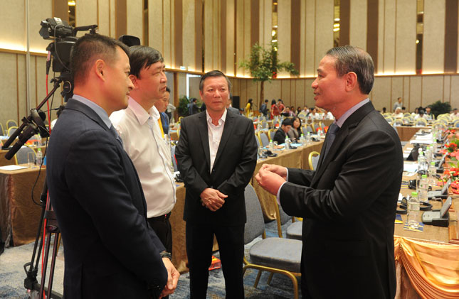 Bí thư Thành ủy Trương Quang Nghĩa (phải) trao đổi cùng các đại biểu bên lề buổi tọa đàm.				                    			                         Ảnh: ĐẶNG NỞ
