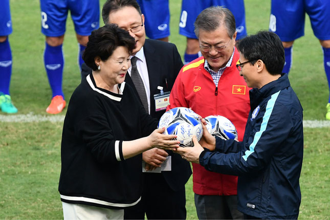 Phó Thủ tướng Vũ Đức Đam (phải) trao tặng quả bóng có chữ ký của các tuyển thủ U23 Việt Nam cho Tổng thống Moon Jae-in (áo đỏ) và đệ nhất phu nhân Kim Jung-sook (trái). Ảnh: GIANG HUY