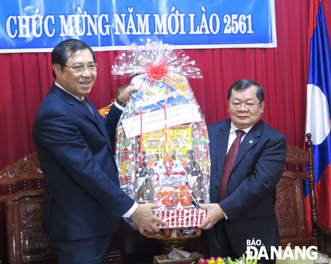 Chủ tịch UBND thành phố Huỳnh Đức Thơ (bên trái) tặng quà cán bộ, nhân viên Tổng Lãnh sự quán Lào nhân dịp Tết cổ truyền Bunpimay 2561. Ảnh: S.TRUNG