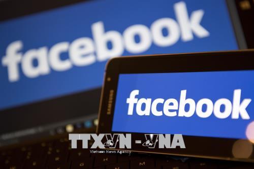Biểu tượng của Facebook trên màn hình điện thoại và máy tính xách tay. Ảnh: AFP/TTXVN