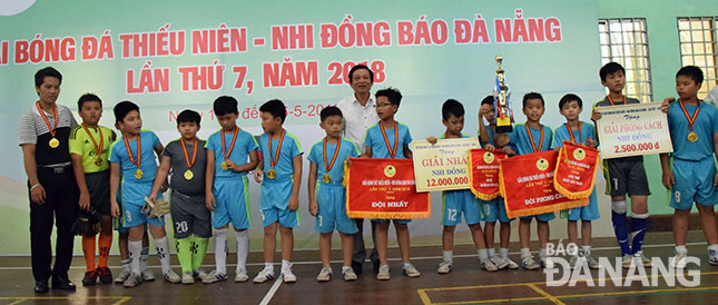 Phó Tổng Biên tập Báo Đà Nẵng Lê Quang Á (áo trắng, giữa), Trưởng Ban tổ chức giải, trao Cúp và Cờ Vô địch cho đội Trường tiểu học Trần Cao Vân.