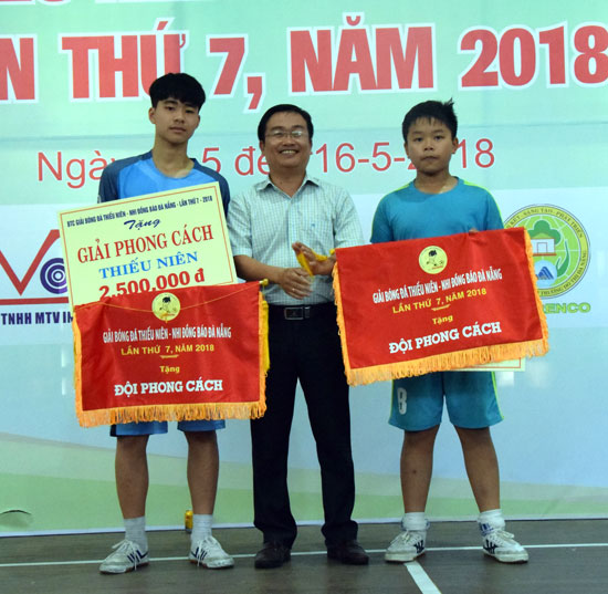 Phó Tổng Biên tập Báo Đà Nẵng Hứa Văn Hải (giữa) trao Cờ cho 2 đội đoạt giải Phong cách là Trường THCS Chu Văn An (trái) và Trường TH Trần Cao Vân (phải).