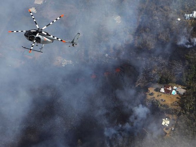 Trực thăng cứu hộ bay trên đám khói đen mù mịt bốc lên từ dung nham núi lửa Kilauea. Ảnh: Getty Images
