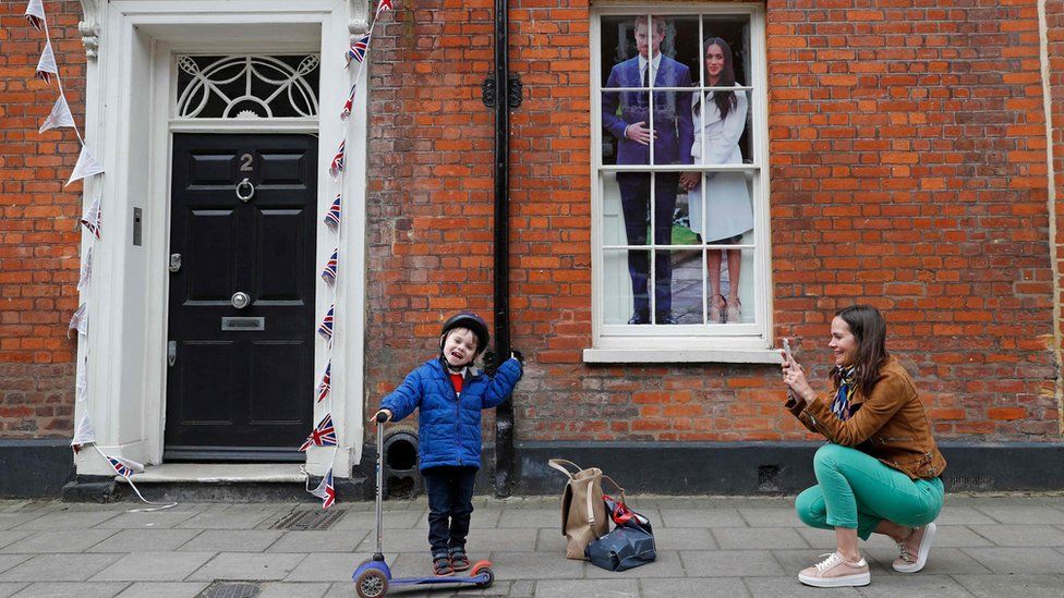Bức ảnh cặp đôi hoàng gia được dán trên khung cửa sổ các hàng quán trong thị trấn. Ảnh: EPA