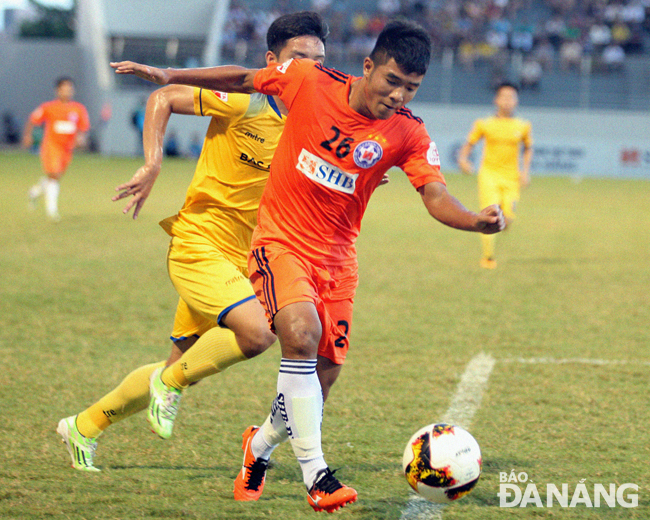 SHB’s striker Ha Duc Chinh (in orange) with the ball