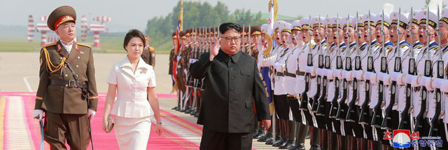 Nhà lãnh đạo Triều Tiên Kim Jong-un và phu nhân bước trên thảm đỏ tại sân bay ở Bắc Kinh.