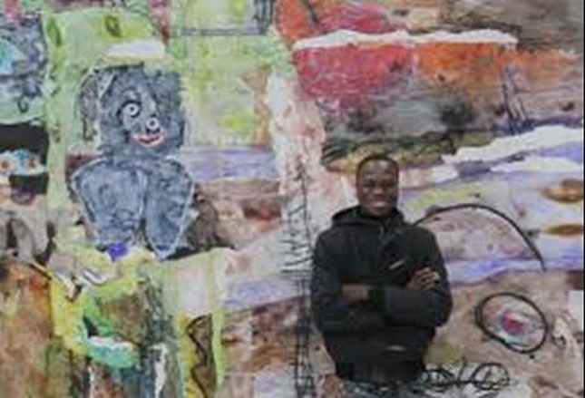 Nghệ sĩ Thierry Oussou trước bức tranh của mình.