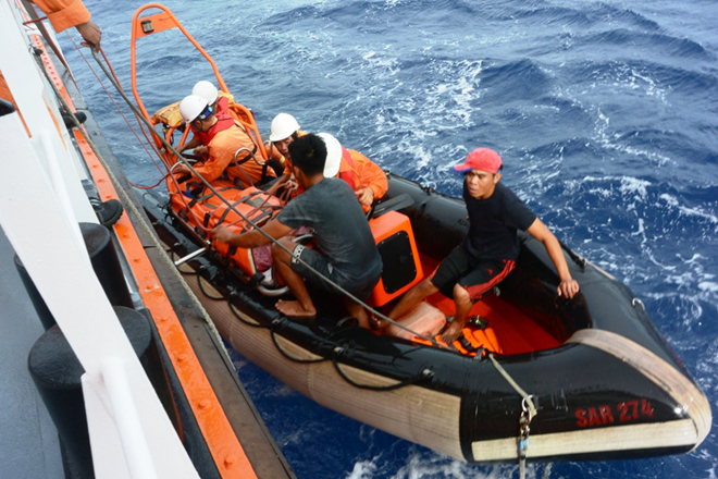 Các thủy thủ tàu Sar 274 đưa thuyền viên bị nạn lên tàu cứu nạn để sơ cứu trước khi chuyển hướng về đất liền