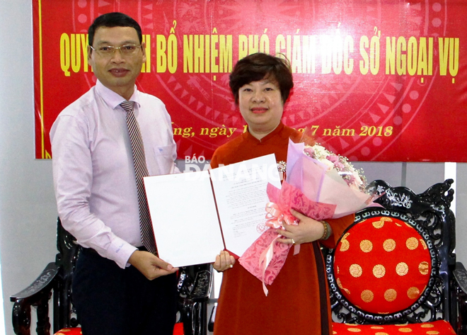 Phó Chủ tịch UBND thành phố Hồ Kỳ Minh (bên trái) trao Quyết định của UBND thành phố về việc bổ nhiệm bà Nguyễn Thúy Anh giữ chức Phó Giám đốc Sở Ngoại vụ. 