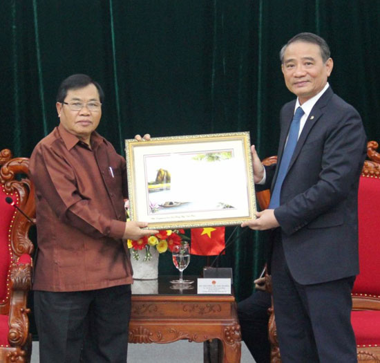 Bí thư Thành ủy Trương Quang Nghĩa (bên phải) tặng quà lưu niệm Phó Chủ tịch Quốc hội Lào. Ảnh: Q.KHẢI