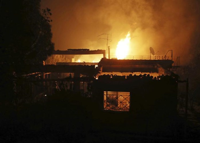 Một ngôi nhà đang bốc cháy dữ dội ở thị trấn phía đông Athen ngày 23/7. Ảnh: AP 
