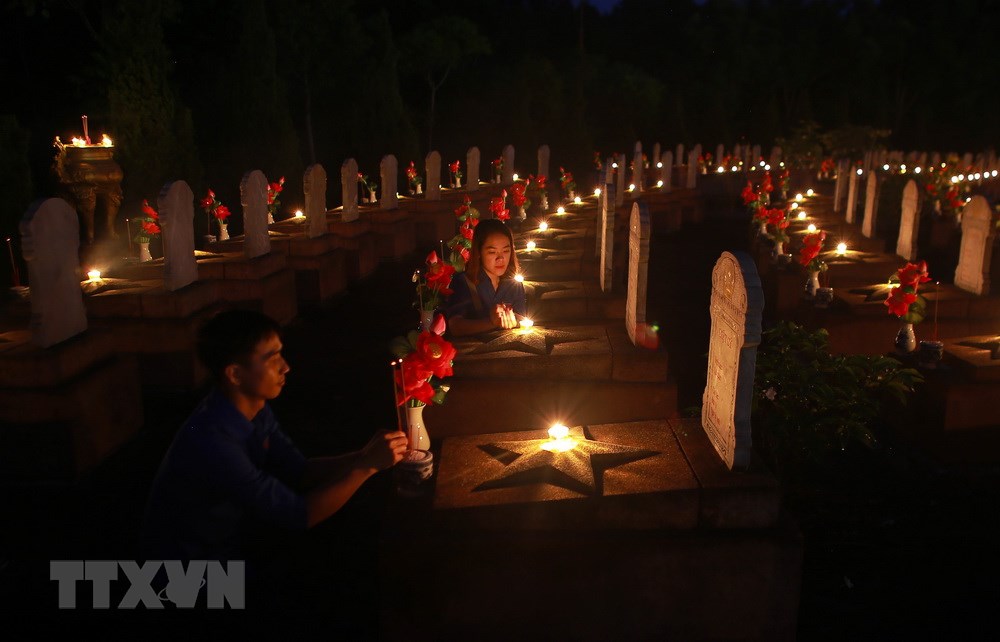 Lực lượng đoàn viên thanh niên Thừa Thiên-Huế thắp nến và hương lên các phần mộ liệt sỹ trong đêm tri ân. (Ảnh: Hồ Cầu/TTXVN)