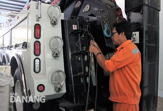 Anh Nguyễn Hoàng Việt đang chế bộ dẫn khí từ xe cứu hộ để mở khóa cho các xe container khi gặp sự cố trong hầm đường bộ Hải Vân. 