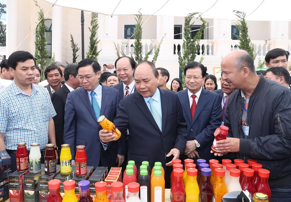Thủ tướng Nguyễn Xuân Phúc và các Phó Thủ tướng tham quan gian trưng bày sản phẩm tại hội nghị. (Ảnh: Thống Nhất/TTXVN)