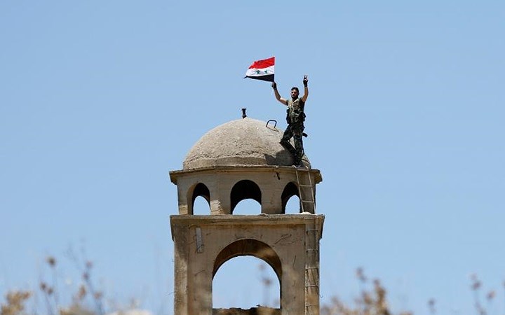 Một binh sĩ quân đội Syria vẫy cờ chiến thắng tại Quneitra.