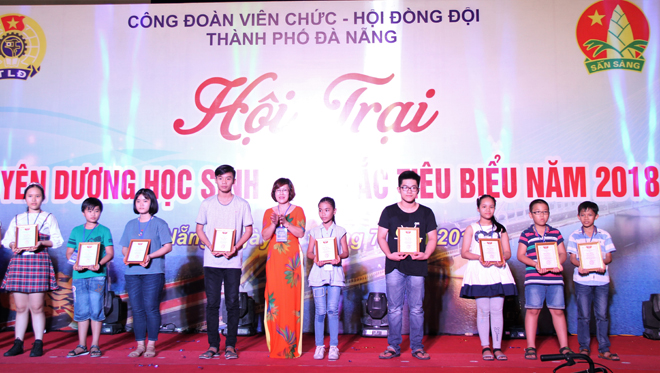Chairwoman of the city's Trade Union Nguyen Thi Tuyet Nhung (6th, right) presenting scholarships to outstanding pupils