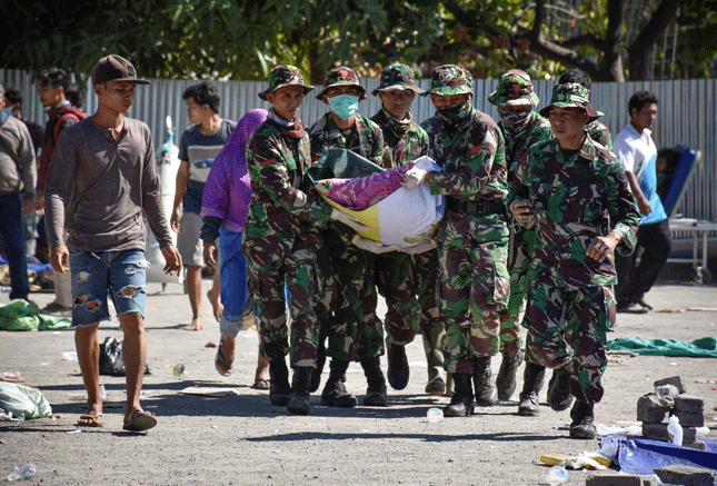 Các quân nhân Indonesia khiêng một thi thể nạn nhân trận động đất ở Tanjung. 					Ảnh: Reuters