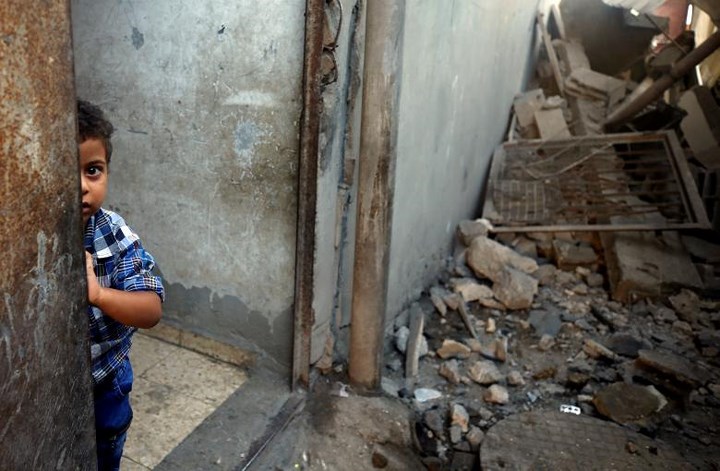 Cậu bé Palestine đứng trong căn nhà ở khu vực Al-Mughraqa bị tàn phá nghiêm trọng vì bom đạn của Israel.