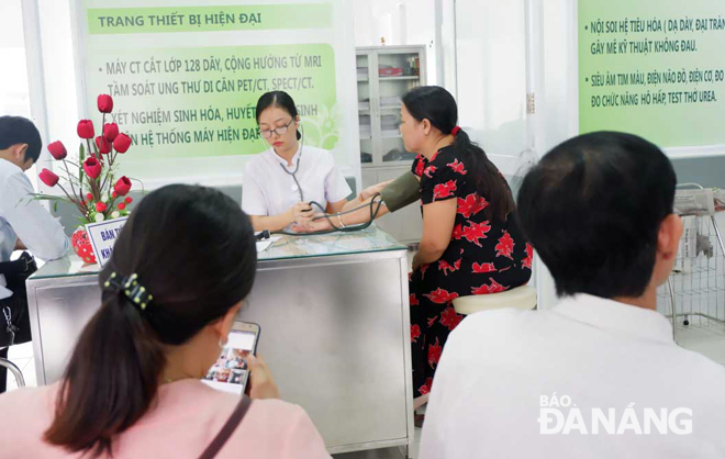 Tăng bàn khám để giảm thời gian chờ đợi của người bệnh và giảm áp lực cho nhân viên y tế. TRONG ẢNH: Bệnh nhân đăng ký khám bệnh tại Bệnh viện C Đà Nẵng.