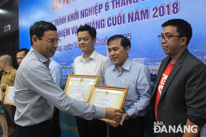 Phó Chủ tịch UBND thành phố Hồ Kỳ Minh tặng bằng khen cho các tập thể, cá nhân có đóng góp tích cực cho hoạt động khởi nghiệp thành phố.  Ảnh: KHANG NINH