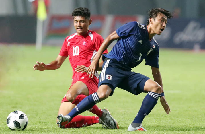 Nepal (áo đỏ) chơi phòng ngự chặt chẽ trong trận thua Olympic Nhật Bản 0-1 tối 14/8. Ảnh: Đức Đồng