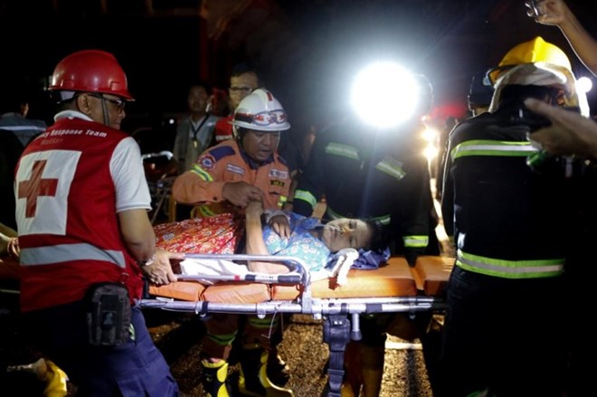Rescuers carry a patient on a stretcher after the fire broke out at Yangon General Hospital (Source: Reuters)