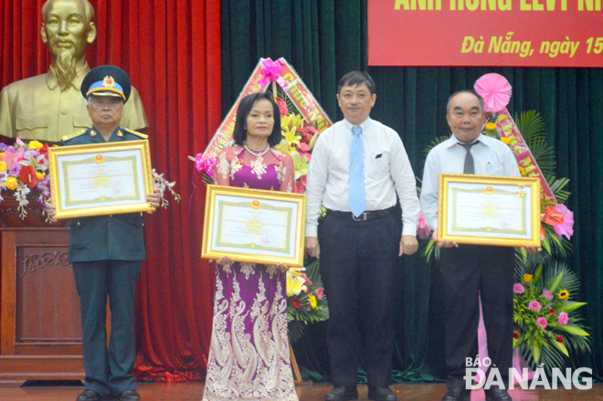 Phó Chủ tịch Thường trực UBND thành phố Đặng Việt Dũng (thứ 2, từ phải) trao tặng danh hiệu Anh hùng LLVTND cho gia đình và các cá nhân. Ảnh: THU THẢO