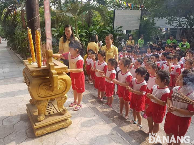 Các em Trường mầm non Ngọc Lan thắp hương tại nghĩa trủng Phước Ninh. Ảnh: Đ.H.L