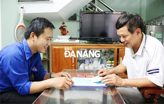 Ông Huỳnh Nam (bên phải) trao đổi với Bí thư Đoàn phường Tam Thuận những công việc phối hợp về hoạt hoạt động thanh niên khu dân cư.