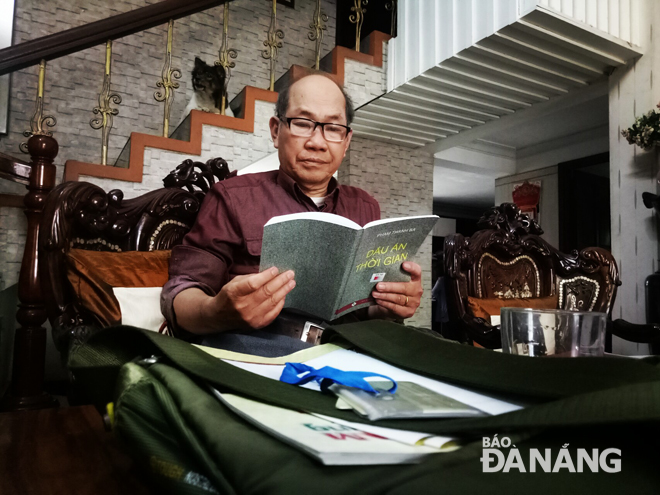 Bác sĩ Nguyễn Như Lễ lần giở tư liệu ghi dấu một thời dấn thân nơi chiến trường bắc Quảng Nam. Ảnh: T.Y