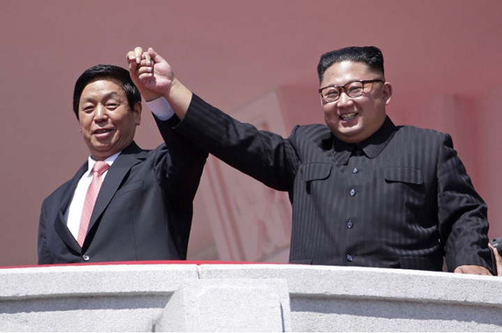Nhà lãnh đạo Triều Tiên Kim Jong-un cùng vị khách Trung Quốc Lật Chiến Thư (trái) -Ủy viên trưởng Ủy ban Thường vụ Đại hội Đại biểu Nhân dân Toàn quốc (tức Chủ tịch Quốc hội) Trung Quốc.
