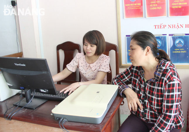 Thành viên tổ tuyên truyền, hỗ trợ thực hiện cải cách hành chính xã Hòa Phước (bên trái) nhiệt tình hỗ trợ người dân.