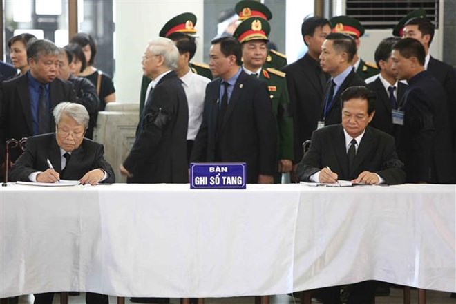 Nguyên Ủy viên Bộ Chính trị, nguyên Chủ tịch nước Trần Đức Lương (bên trái) và nguyên Ủy viên Bộ Chính trị, nguyên Thủ tướng Chính phủ Nguyễn Tấn Dũng (bên phải) ghi sổ tang. Ảnh: TTXVN