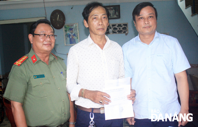 Ông Phạm Nam Sơn, Phó Chủ tịch UBND quận Cẩm Lệ (phải) trao  5 triệu đồng hỗ trợ anh Phùng Văn Thắng.