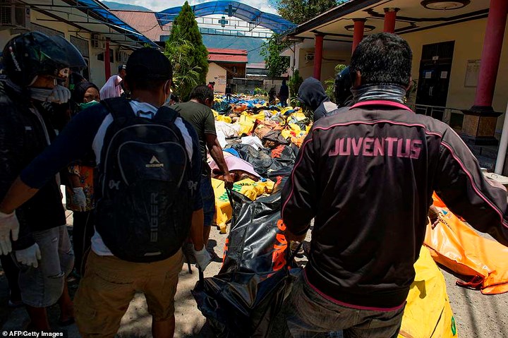   Các nhân viên cứu nạn khiêng thi thể của một nạn nhân trong vụ động đất sóng thần tới một bệnh viện ở Palu. Ảnh: AFP
