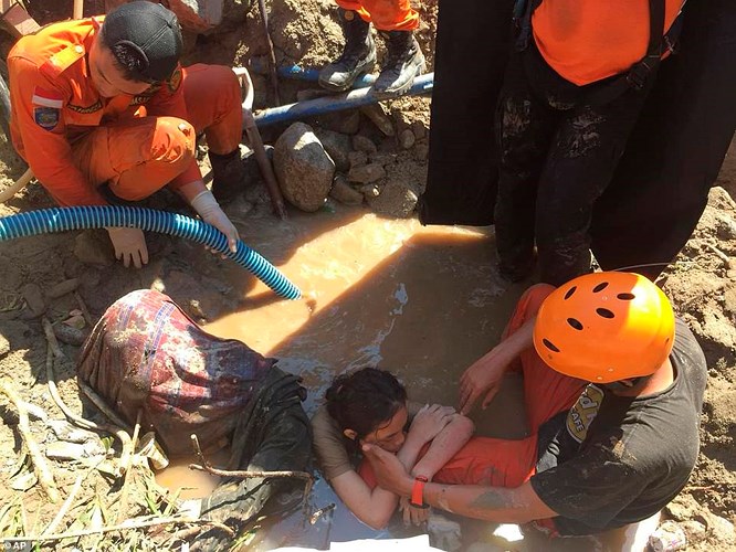 Một đội cứu hộ đang cố gắng giúp một phụ nữ mắc kẹt dưới bùn đất ngày 30/9 thoát ra ngoài. Nhiều người lo ngại vẫn còn hàng nghìn người bị kẹt dưới các đống đổ nát sau trận động đất kinh hoàng xảy ra ngày 28/9. Ảnh: AP 