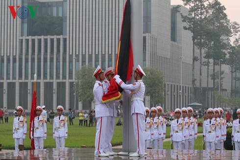Công việc buộc dải băng đen vào cờ Tổ quốc được tiến hành.