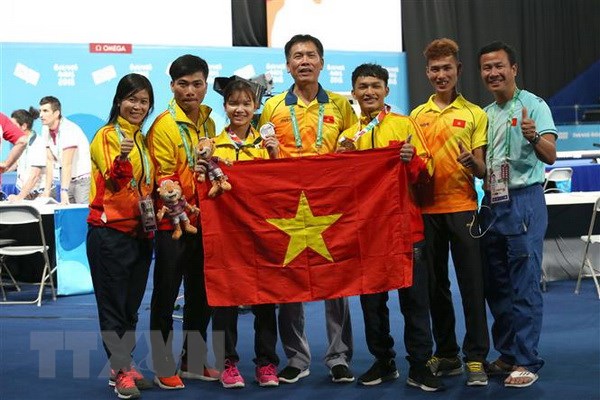 Đoàn Việt Nam chia vui với các vận động viên cử tạ đoạt huy chương vàng và huy chương bạc trong ngày thi đấu đầu tiên. (Ảnh: Hoài Nam/TTXVN)