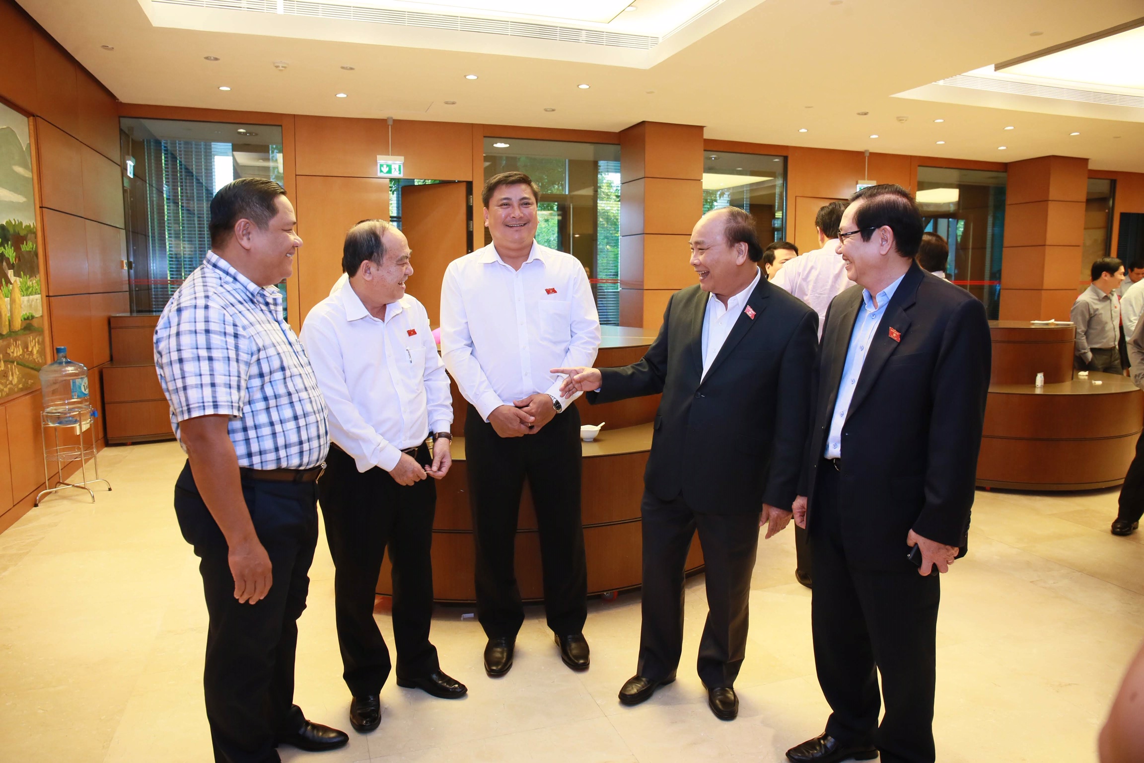 Thủ tướng Chính phủ Nguyễn Xuân Phúc trao đổi với các đại biểu bên hành lang Quốc hội. Ảnh VGP