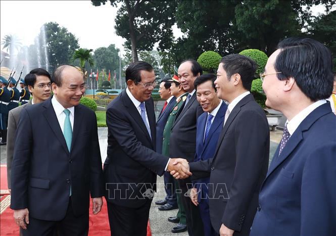 Thủ tướng Campuchia Samdech Techo Hun Sen bắt tay các thành viên chính thức đoàn Việt Nam tham dự lễ đón. Ảnh: Thống Nhất/TTXVN