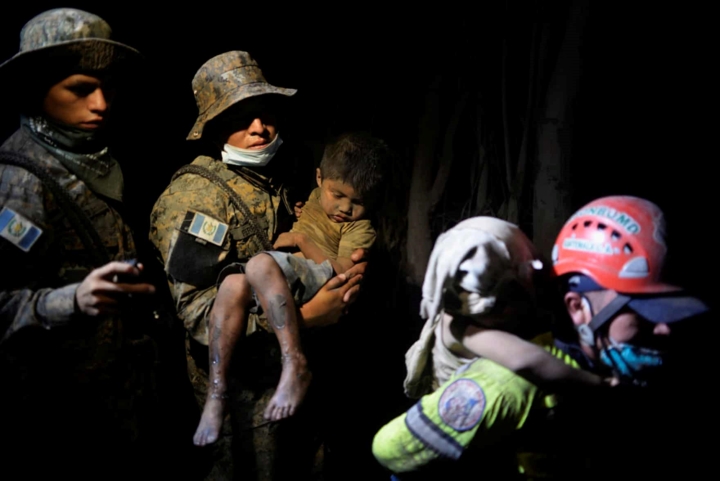 Người lính cứu hộ bế một em bé vừa được cứu ra khỏi khu vực bị ảnh hưởng trong vụ núi lửa phun trào kinh hoàng ở Guatemala. Ảnh: Reuters 