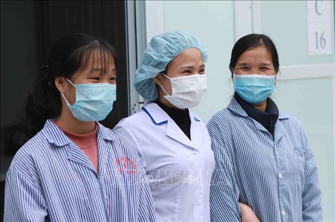 Nhân viên y tế phòng khám đa khoa khu vực Quang Hà chúc mừng hai bệnh nhân ra viện.