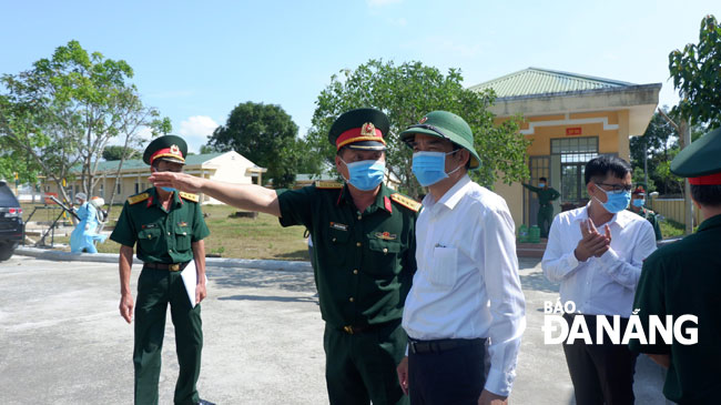 Phó Chủ tịch UBND thành phố Lê Trung Chinh (áo trắng) kiểm tra việc cách ly, theo dõi sức khỏe các công dân tại Trung tâm huấn luyện dự bị Đồng Nghệ sáng 26-2. Ảnh: PHAN CHUNG