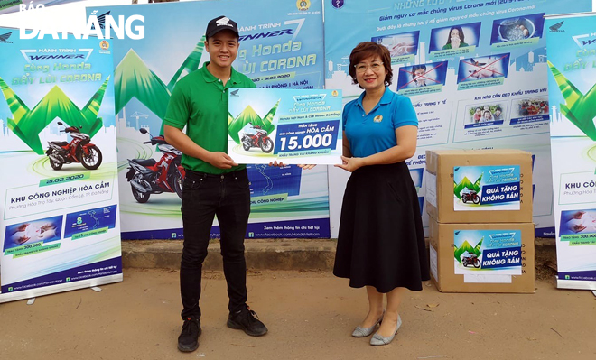 Bà Đinh Thị Thanh Hà (phải), Phó Chủ tịch Liên đoàn Lao động thành phố tiếp nhận quà tặng của nhãn hàng Honda Việt Nam để cấp phát cho công nhân lao động ở Khu công nghiệp Hòa Cầm.       								        Ảnh: NGỌC CHÂN