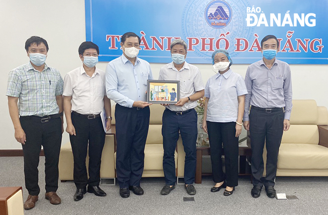  Da Nang People’s Committee Chairman Huynh Duc Tho (3rd, left) presenting a momento to members of the Ministry of Health-dispatched Covid-19 special task force before their Ha Noi comeback 