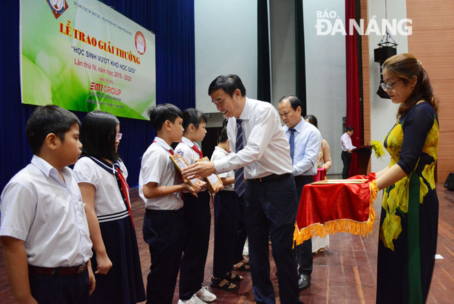 Đồng chí Lê Trung Chinh trao giấy khen cho các học sinh nhận Giải thưởng Học sinh vượt khó học giỏi năm học 2019-2020. Ảnh: LÊ VĂN THƠM 